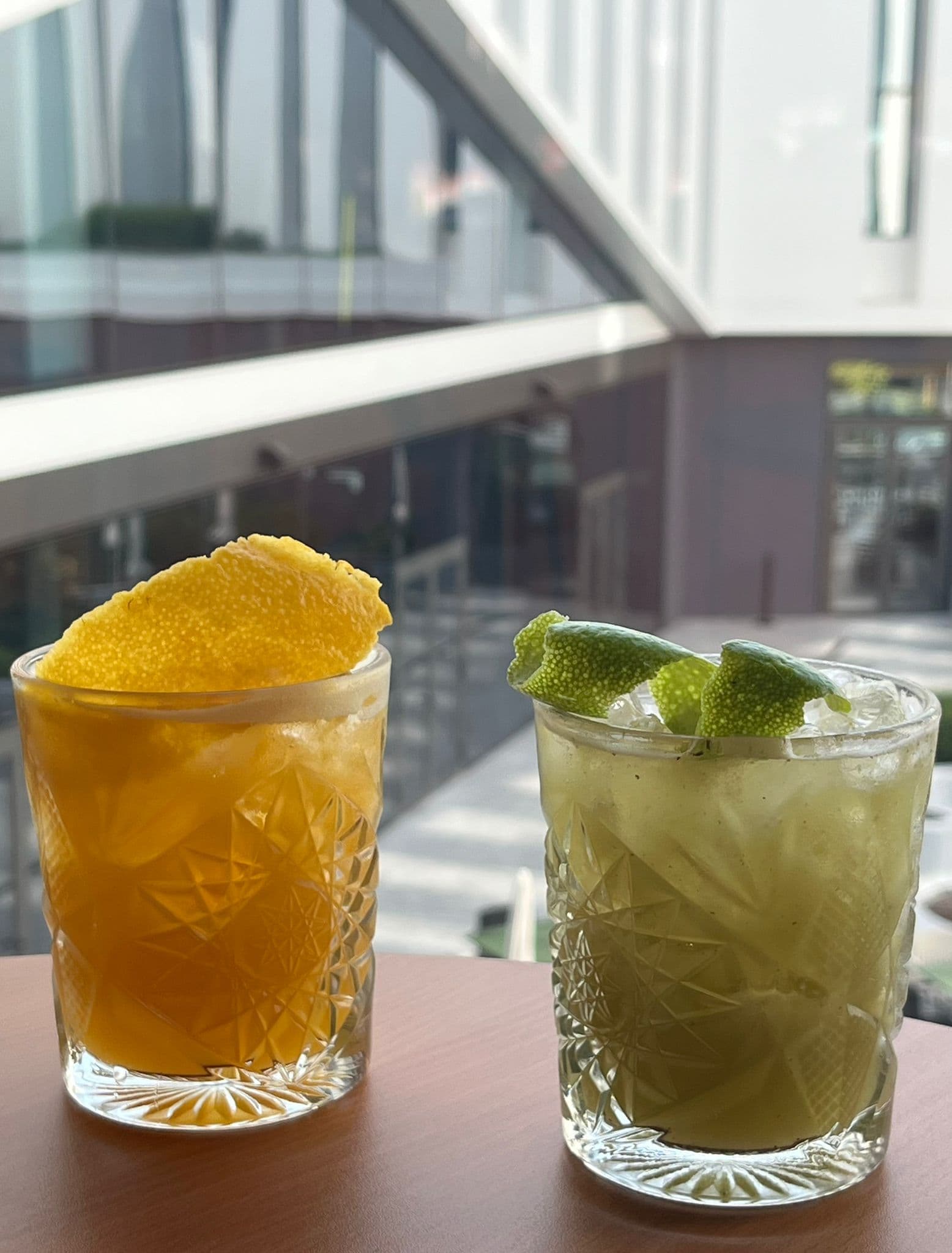 Dois cocktails cítricos em copos lapidados