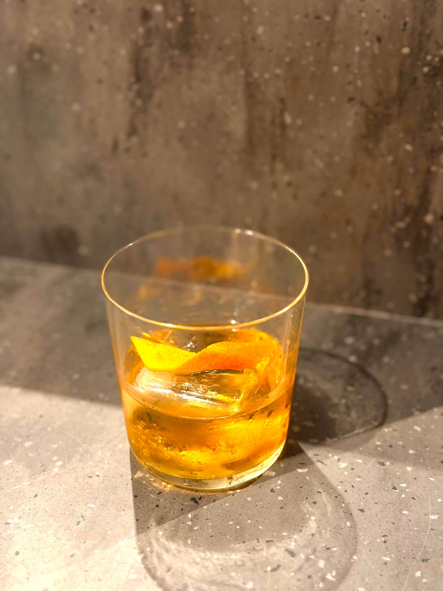 Old Fashioned com casca de laranja ao sol