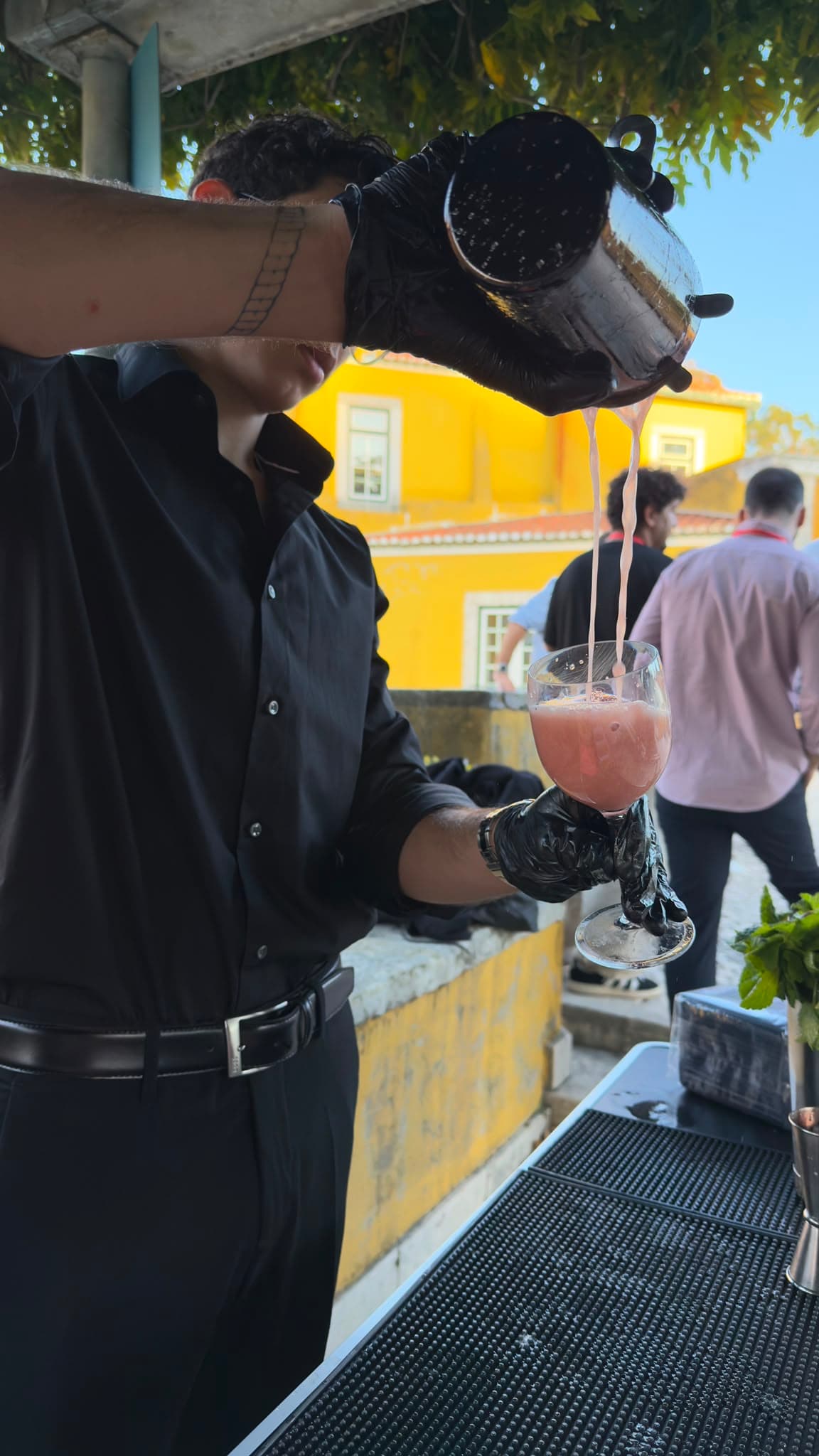 Bartender a servir um cocktail num evento ao ar livre